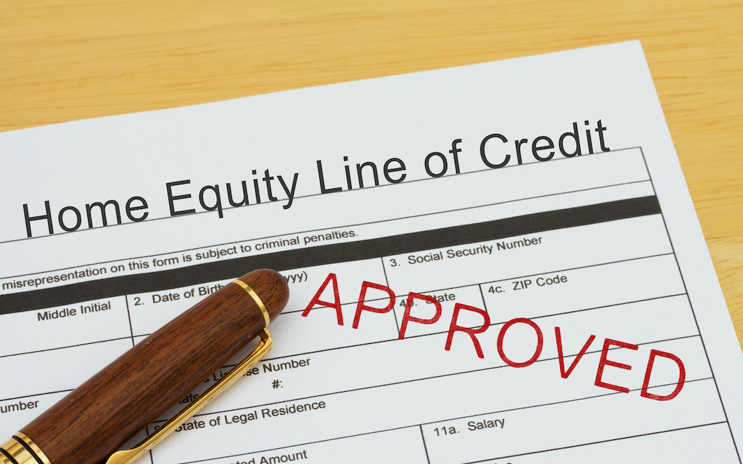 Applying for a Home Equity Line of Credit Approved, Home Equity Line of Credit application form with a pen on a desk with an approved stamp